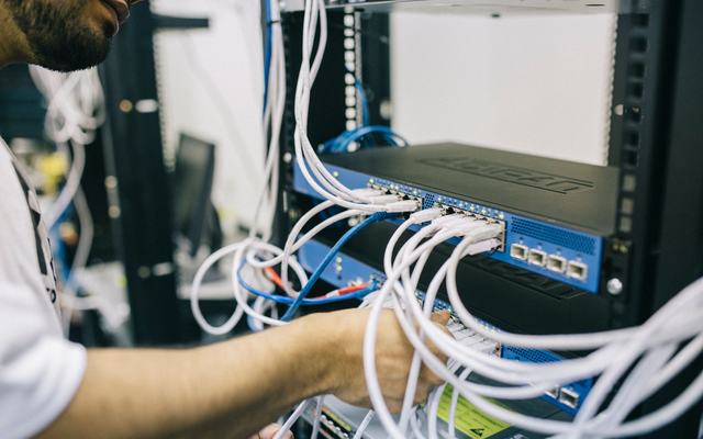 Network engineer wiring a patch panel